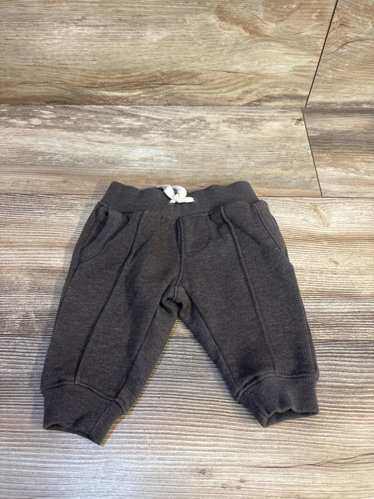 Dark gray toddler joggers with white drawstring, laid on wood floor — kids clothing resale