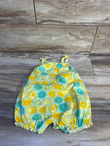 Top-down view of Henley lemon tank romper showcasing lemon print, knotted shoulder straps and snap crotch on wood floor