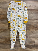 Baby sleeper pajamas with construction vehicle and traffic sign print, yellow trim, on wood floor