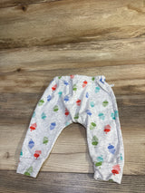 Flat lay of grey baby harem pants showing multicolored acorn print, elastic waistband and cuffed ankles on wood background