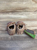 Tan suede baby moccasins with fringe and bows on wood background, resale kids shoes