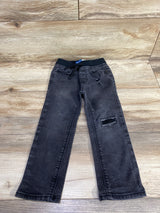 Black denim kids jeans with elastic waistband and patch detail, displayed on wood floor
