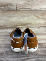 Rear view of Cat & Jack Enzo toddler slip-on sneakers in tan showing white rubber soles with black stripe and size 2 tag on wood floor