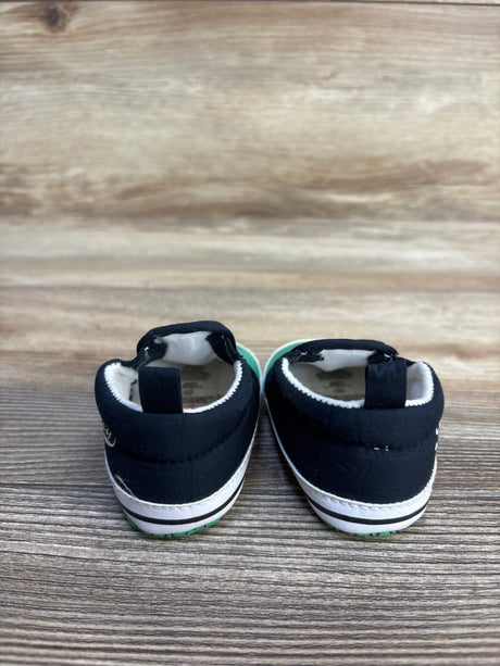 Back view of black and white baby shoes on a wooden floor, kids footwear resale