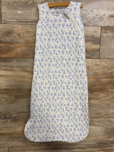 Front view of Angel Dear 1.0 TOG white sleep bag showcasing small blue floral-and-bow pattern and diagonal zipper, laid flat on wood floor