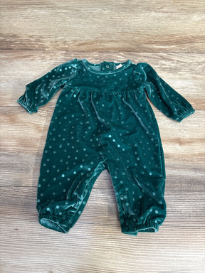 Velvet dark green baby romper with polka dot pattern on wooden surface