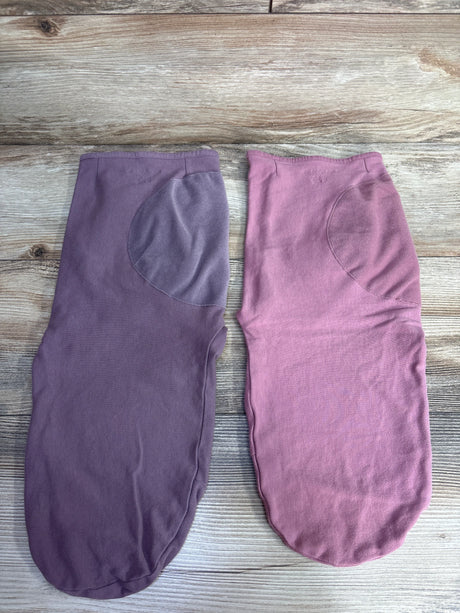 Two folded warm mittens on wooden surface, one in purple, one in pink, with thumb patches