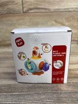 Front view of Happy Play Puzzle Busy Ball box with rotating puzzle panels and retractable rope on wooden floor