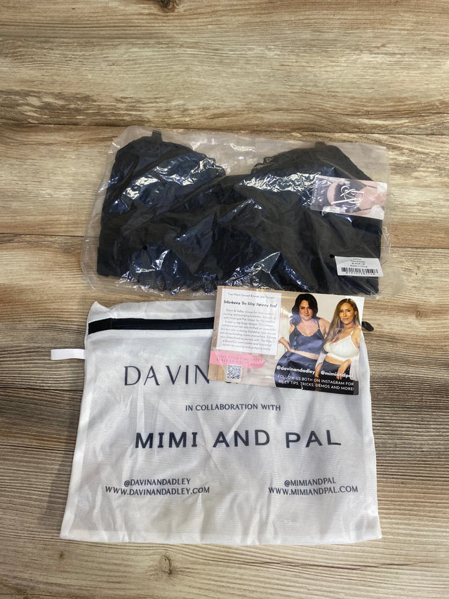 Black nursing and pumping bra in clear packaging with white Davin and Adley cloth bag, promotional card on wood surface