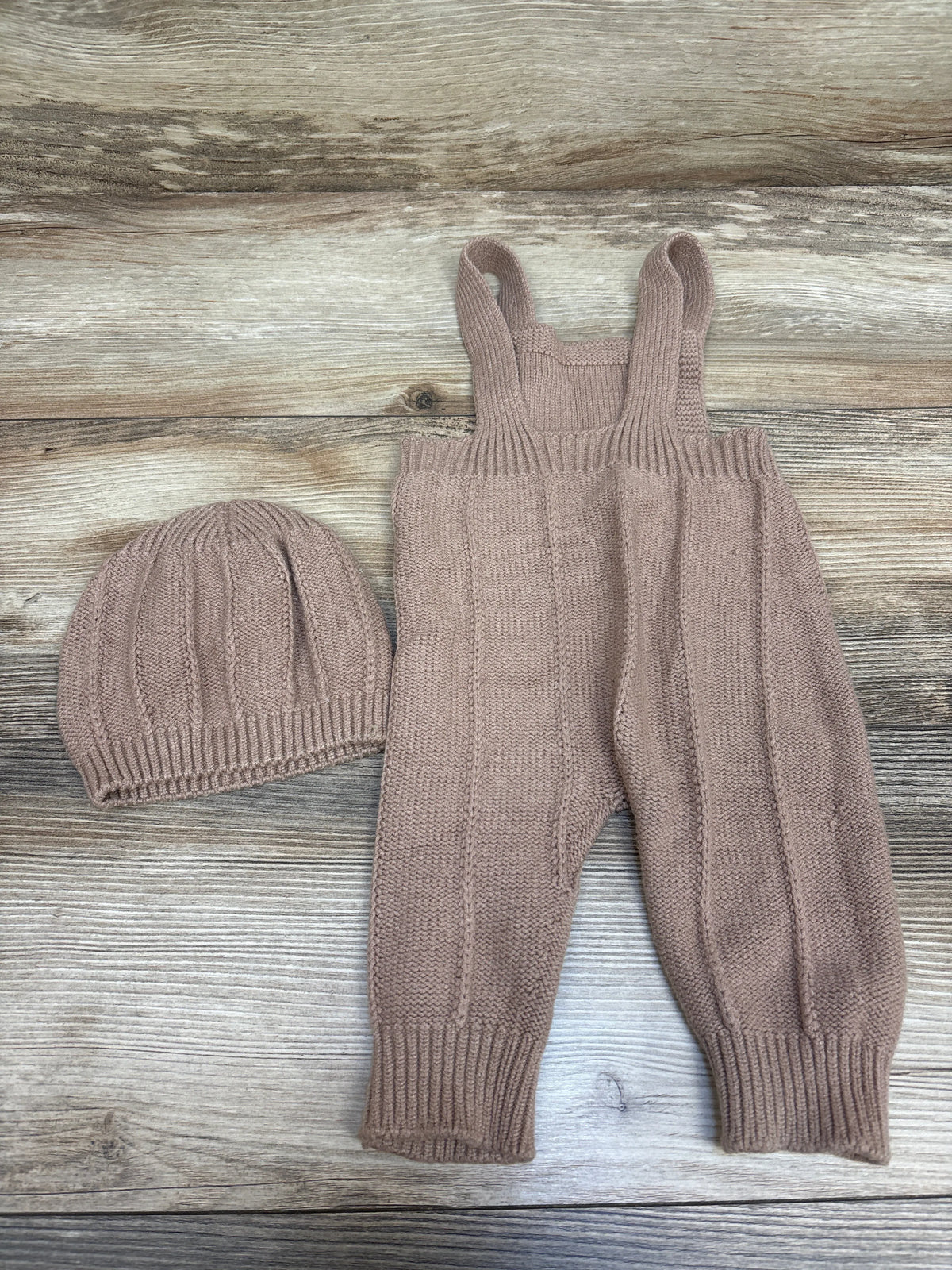 Top view of Shein tan knit overalls and matching hat set showcasing ribbed cuffs and shoulder straps on a wood-grain background