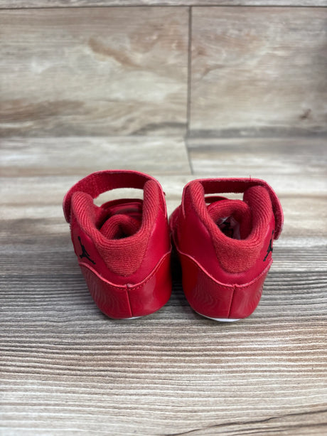 Rear view of Air Jordan 11 Retro Win Like 96 sneakers showcasing red padded collars and Jordan logos on a wood grain background