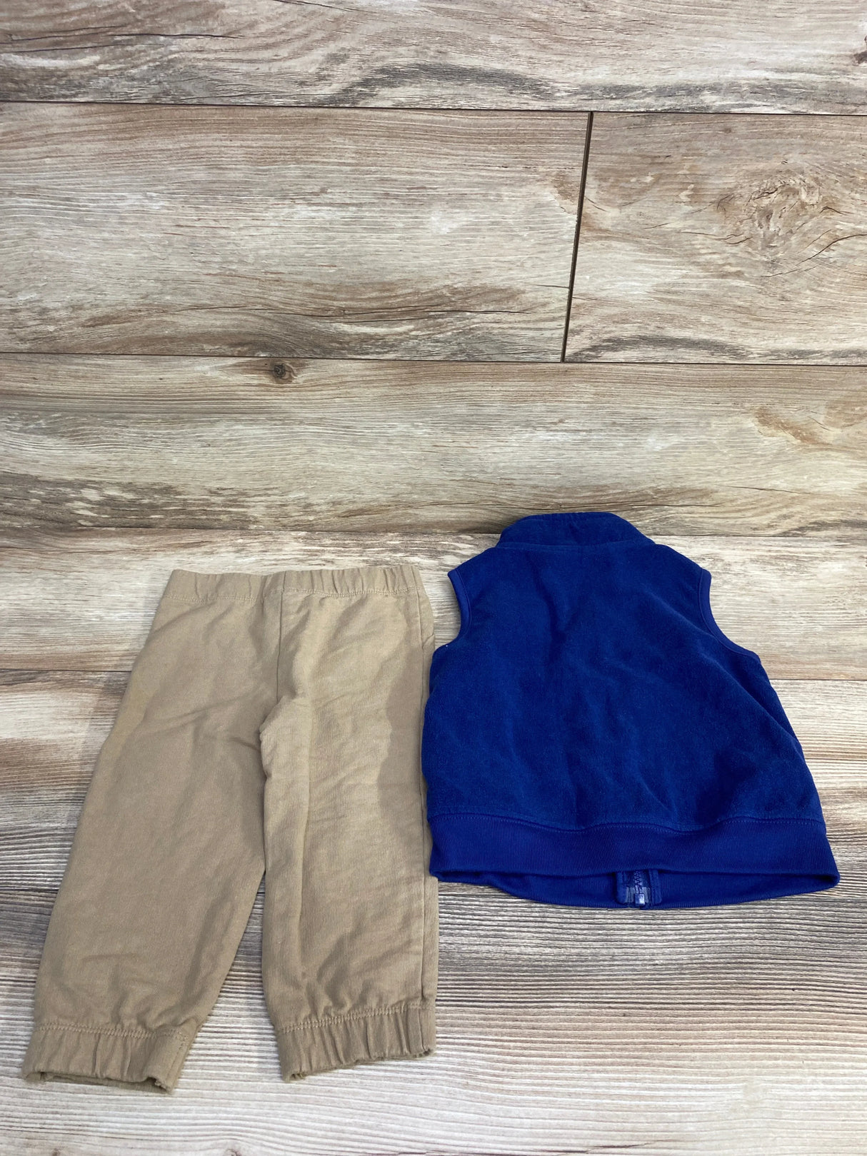 Back of Carter's navy fleece vest and khaki toddler pants, size 18M, elastic waist pants on wood background