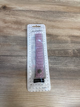 Pink braided wristlet keychain in retail packaging on wooden surface