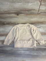 Beige long sleeve kids sweatshirt laid flat on wood background, children's clothing resale