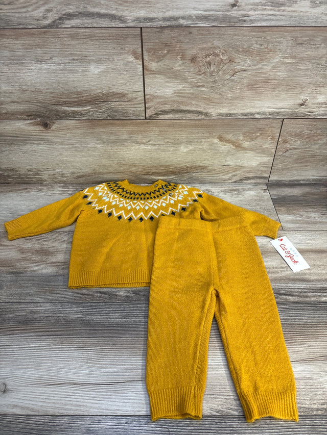 Yellow knit toddler sweater and pants set with geometric pattern on wood background