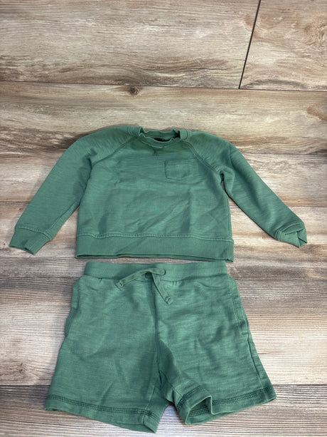 Flat lay of Janie & Jack green sweatshirt and shorts size 5T showing chest pocket and drawstring waist on wood background