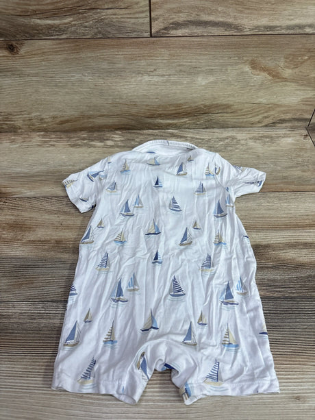 Flat lay of Angel Dear Bamboo Polo Shortie Romper in white with blue sailboat print on a wood background