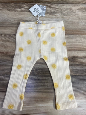 White ribbed baby leggings with yellow sun patterns on wooden floor, Kate Quinn tag attached