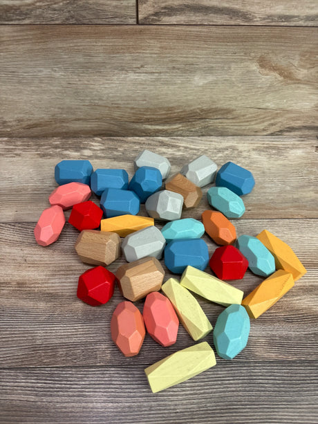 Overhead view of BESTAMTOY 30pc Wooden Stacking 7 Sorting Colorful Stones showcasing colorful faceted wooden pieces on a wood-grain surface