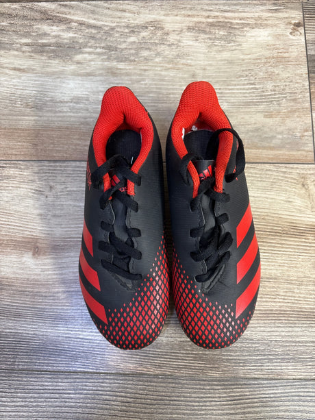 Top view of Adidas Predator 20.4 soccer cleats showing red and black upper, lace closure, molded FxG studs on wood floor