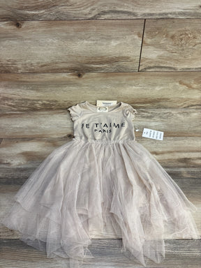 Flat lay of Mia Joy Feya toddler dress 3T with sand bodice reading Je T'aime Paris and layered tulle skirt on wood floor