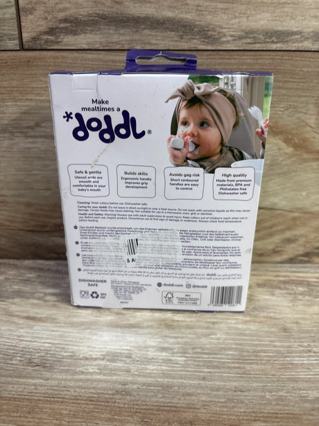 Back view of Doddl Baby Spoon and Fork Set box with safe gentle claims and Make mealtimes a doddle text on wood grain