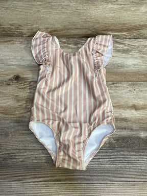 Flat lay of Pehr ruffle swimsuit in peony pink and white stripes showing ruffled cap sleeves on wood background