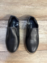 Black slip-on boys shoes size 10 with tan soles on wood background