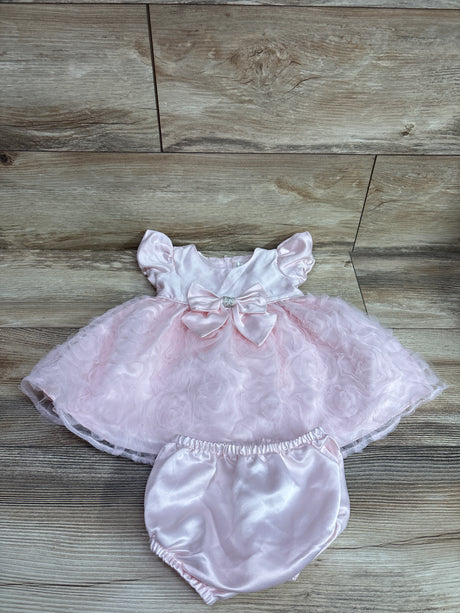 Top-down view of Rare Editions pink tulle dress and bloomers set showcasing satin bow and layered skirt on a wood floor