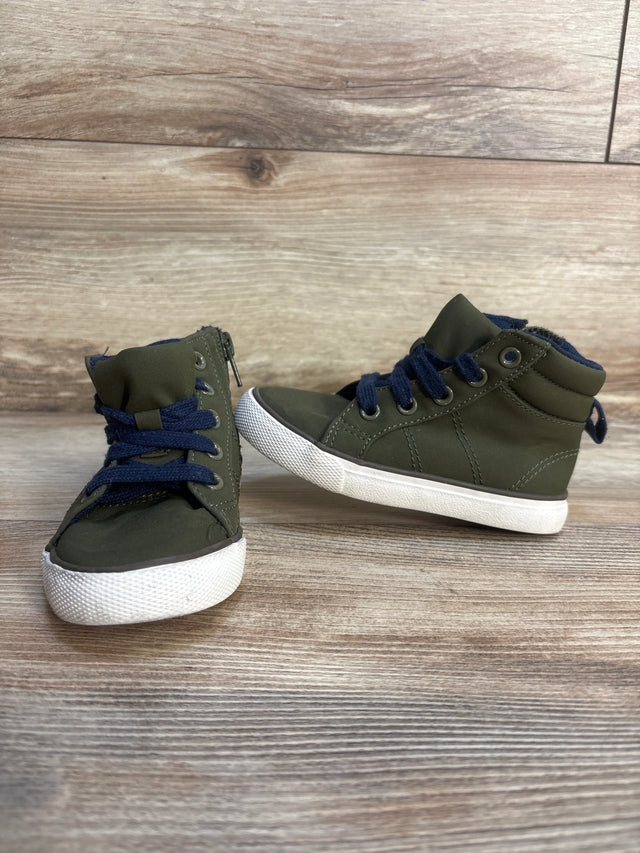 Olive green toddler high top sneakers with blue laces on wood background