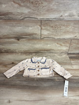 Front flat-lay of beige Nicole Miller toddler denim jacket with lace trim, buttons, front pockets, 12M tag on wood background
