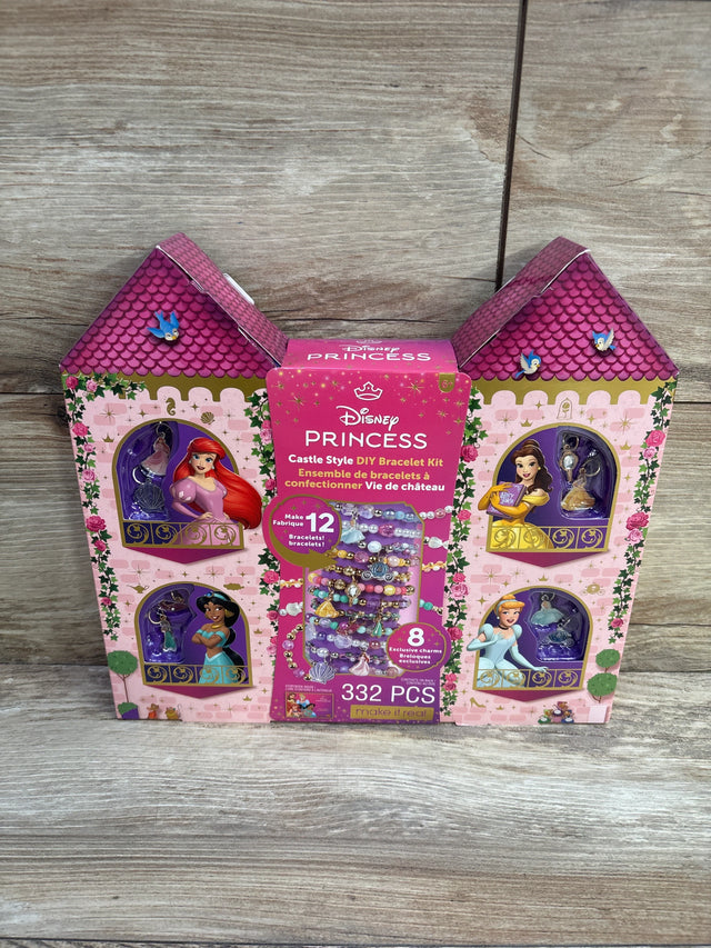 Front view of Disney Princess castle-style bracelet kit box showing 332 pieces and sample bracelets on a wooden surface