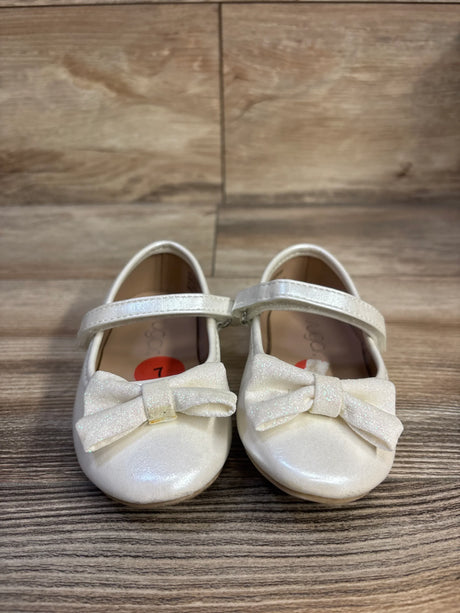 Front view of Sugar Nira white toddler flats showcasing glitter bows and Mary Jane strap on wood floor