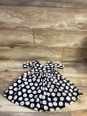Front view of Hanna Andersson polka dot skater dress, size 3T, showcasing black fabric with white polka dots on wood floor
