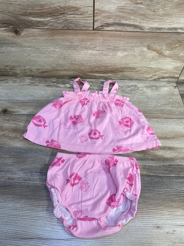Flat lay of pink two-piece tank top and bloomer set showing fish print and elastic waistbands on light wood background