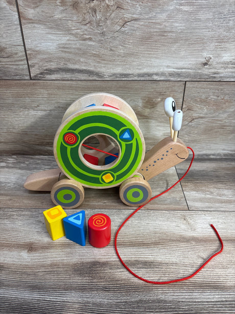 Wooden pull-along snail toy with colorful geometric blocks on wood floor