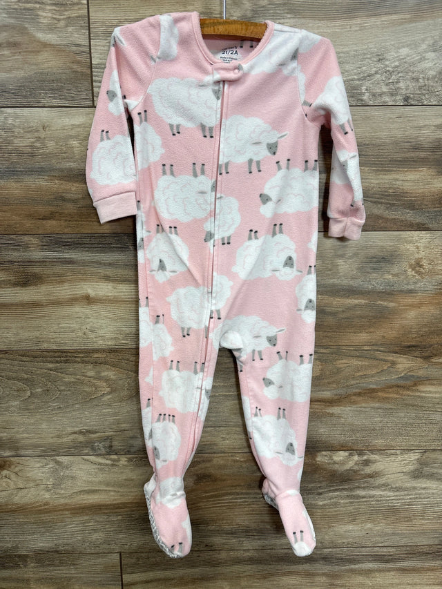 Pink fleece baby sleeper with white sheep print and zipper on wooden floor