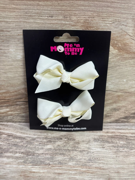 Two ivory grosgrain hair bows on a Me n Mommy To Be branded black display card.