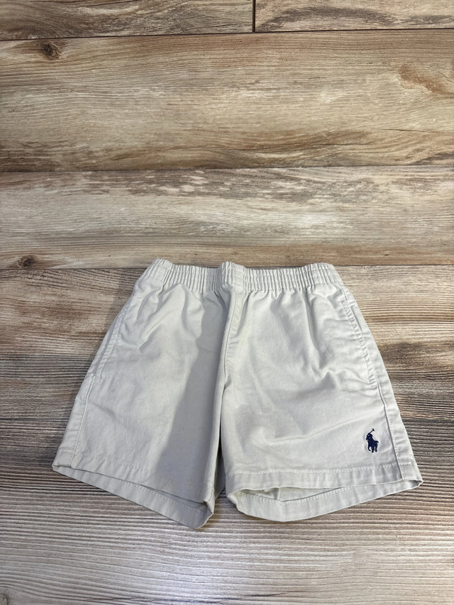 Front view of khaki Polo Ralph Lauren toddler shorts showcasing elastic waistband and navy embroidered pony on wood background