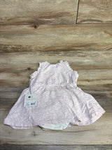 Flat-lay of pink Cloud Island tank dress with bloomers, ruffle sleeves and floral print on wood background