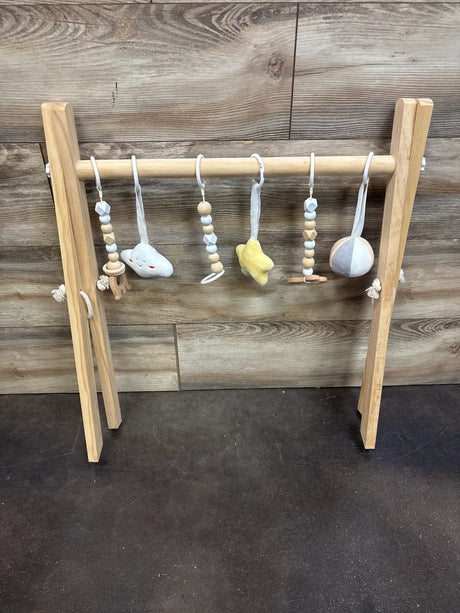 Front view of Mallify Wooden Baby Activity Gym showcasing its wooden frame and hanging toys against a wood plank background