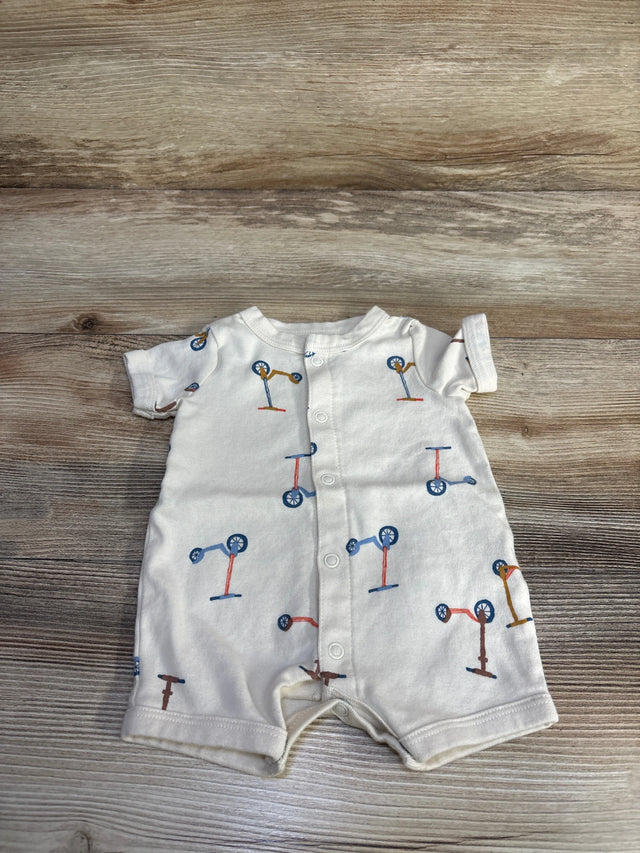Front view of beige Carter's shortie romper showcasing button-front snaps and scooter print on a light wood background