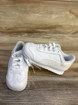 White Puma Roma toddler sneakers with laces on wood background, gently used kids shoes