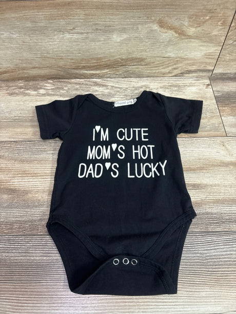 Black Floral Pig baby bodysuit with 'I'm Cute Mom's Hot Dad's Lucky' text on a wood background