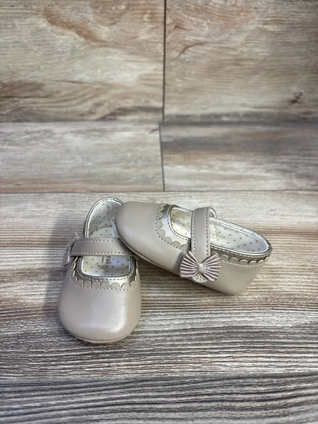 Front and side view of Mayoral Mary Jane shoe in tan showing scalloped trim and bow on strap on wood-look background