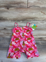 Top-down view of pink Shein x Scooby-Doo romper showing heart and Scooby print, thin straps, and tag on wood background