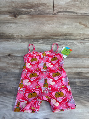 Top-down view of pink Shein x Scooby-Doo romper showing heart and Scooby print, thin straps, and tag on wood background