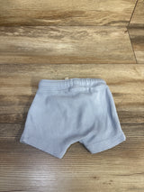 Top view of newborn blue Old Navy waffle knit pull on shorts showing ribbed texture and elastic waistband on wood background
