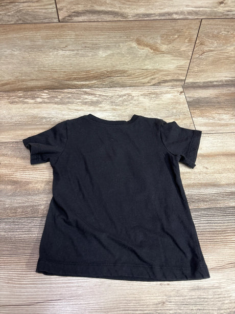Top view of The Prince Estate Purple Rain black shirt, size 3T, showing short sleeves and crew neckline on wood-look flooring