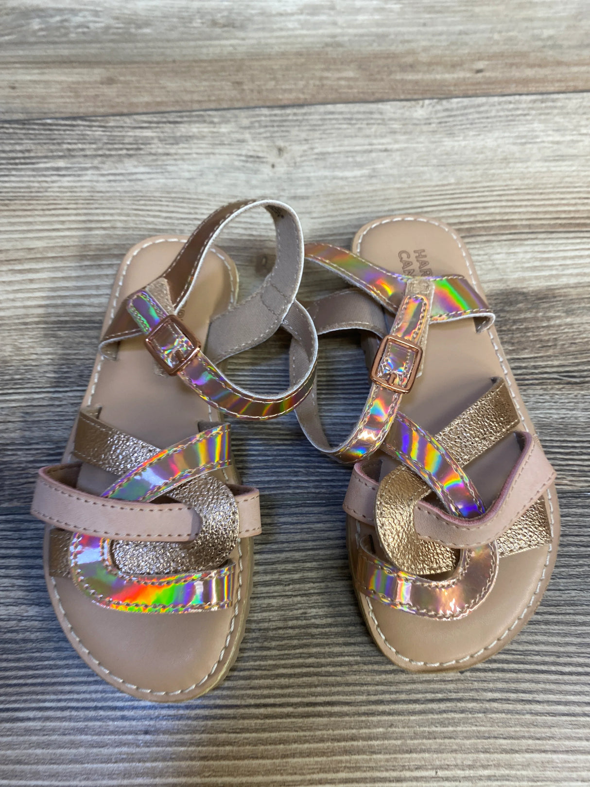 Girls' iridescent strappy sandals with metallic details on wood background
